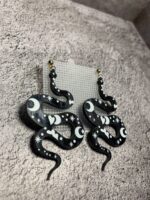 Представляем эффектные серьги в виде изящных змеек — смелое и стильное украшение для истинных ценительниц необычных аксессуаров! Эти серьги сразу привлекают внимание благодаря яркому дизайну и завораживающему сочетанию оттенков черного и белого..