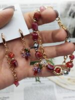 Комплект украшений: браслет и серьги «Яркая элегантность» Позвольте себе окунуться в мир утончённой роскоши с этим изысканным комплектом — браслетом и серьгами, которые станут настоящей изюминкой вашего образа. Сочетание золотистых цепочек и многогранных бусин создаёт эффектный, но гармоничный акцент, который подойдёт как для повседневной носки, так и для особых случаев.