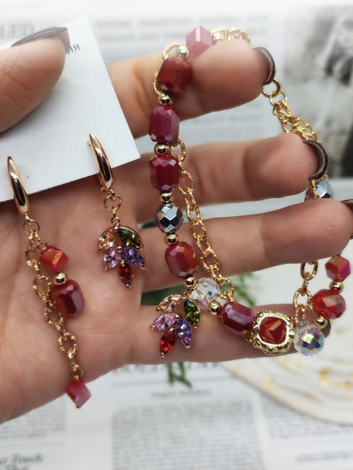 Комплект украшений: браслет и серьги «Яркая элегантность» Позвольте себе окунуться в мир утончённой роскоши с этим изысканным комплектом — браслетом и серьгами, которые станут настоящей изюминкой вашего образа. Сочетание золотистых цепочек и многогранных бусин создаёт эффектный, но гармоничный акцент, который подойдёт как для повседневной носки, так и для особых случаев.