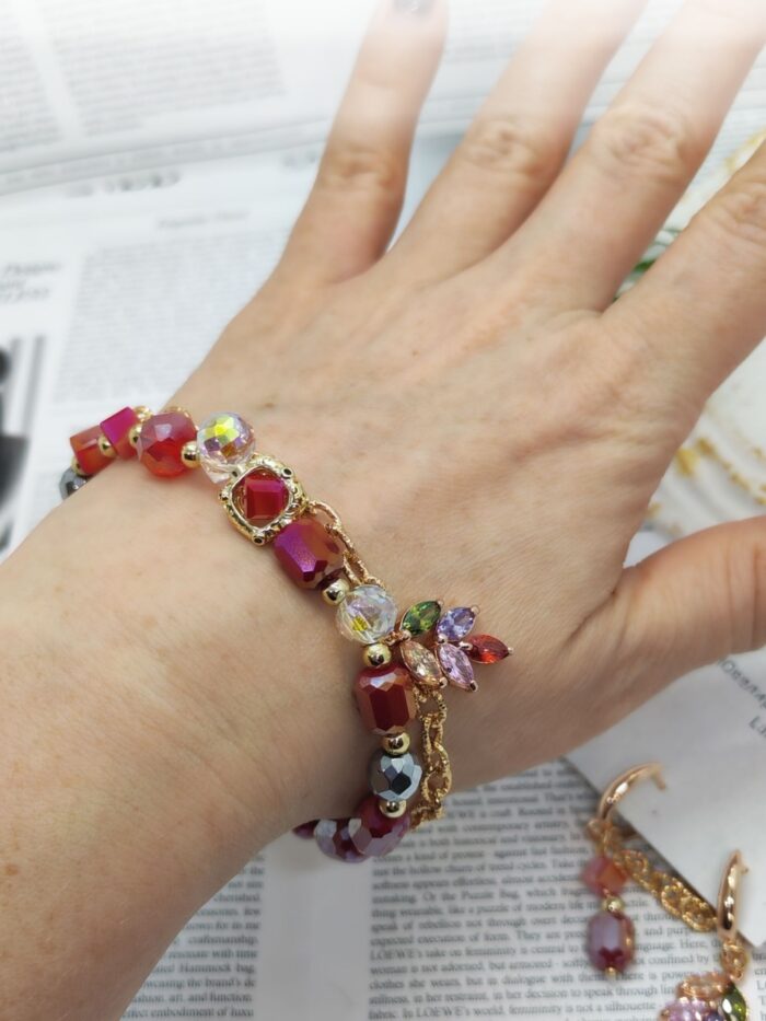 Комплект украшений: браслет и серьги «Яркая элегантность» Позвольте себе окунуться в мир утончённой роскоши с этим изысканным комплектом — браслетом и серьгами, которые станут настоящей изюминкой вашего образа. Сочетание золотистых цепочек и многогранных бусин создаёт эффектный, но гармоничный акцент, который подойдёт как для повседневной носки, так и для особых случаев.