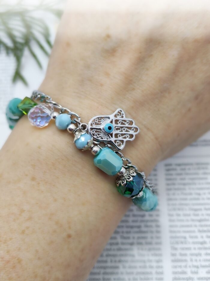 Браслет взгляд хамсы Представляем изысканный браслет ручной работы, сочетающий в себе элегантность и загадочность. Этот аксессуар — настоящее произведение искусства, в котором гармонично переплелись натуральные оттенки зелёного и бирюзового, блеск металла и магия символики.