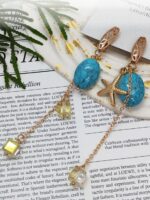 Серьги «Морская элегия»: гармония бирюзы и золота Погрузитесь в атмосферу морского бриза с изысканными серьгами, сочетающими природную красоту бирюзы и утончённость золотых элементов. Эта пара украшений — настоящий гимн лету и свободе, воплощённый в деталях.