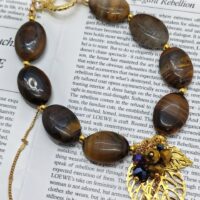 Браслет Тигровый акцент Браслет с тигровым глазом и золотыми элементами: гармония силы и изящества. Откройте для себя магию природных камней с этим изысканным браслетом, сочетающим в себе мощь тигрового глаза и утончённость золотых деталей. Украшение станет не только стильным аксессуаром, но и вашим личным талисманом.