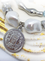 Браслет с жемчугом Майорка и сахарным кварцем: воплощение элегантности и индивидуальности Ищете украшение, которое подчеркнёт вашу утончённость и добавит нотку роскоши в любой образ? Представляем вам эксклюзивный браслет, сочетающий в себе изысканность жемчуга, нежность кварца и изящество серебряных элементов. Почему этот браслет заслуживает вашего внимания? · Роскошный дизайн. Крупные жемчужные бусины неправильной формы создают ощущение природной гармонии и уникальности. Нежно-голубой кварц напоминает о морском бризе и добавляет свежести образу. · Сочетание материалов. Серебряные элементы разной формы (гладкие, фактурные, изогнутые) создают интересную игру линий и текстур, делая браслет по-настоящему уникальным. · Особая деталь — монета-подвеска. Центральный элемент украшения — стилизованная монета с рельефным изображением. Она придаёт браслету винтажный шарм и делает его настоящим акцентом в образе. · Универсальность. Этот браслет легко сочетается как с повседневной одеждой, так и с вечерними нарядами. Он подойдёт для офиса, романтического ужина или торжественного мероприятия. · Три в одном. Этот аксессуар можно разделить на три самостоятельных браслета. Можно носить все сразу или по оному... Все, как пожелает ваше настроение · Качество исполнения. Каждый элемент тщательно подобран и надёжно закреплён. Браслет удобен в носке и не теряет внешний вид со временем. Идеальный подарок! Ищете подарок для особенной женщины? Этот браслет станет символом вашей заботы и внимания. Он подойдёт как для молодой девушки, так и для зрелой дамы, ценящей классику и элегантность. Не упустите возможность пополнить свою коллекцию украшений настоящим произведением искусства! Добавьте этот браслет в корзину уже сегодня и позвольте себе наслаждаться его красотой каждый день. Для заказа и по всем вопросам обращайтесь Телефон: +79817339605 WhatsApp: wa.me/79817339605 Группа в Telegram: t.me/LanaMir03 Сообщения группы VK: vk.me/lanamirc Группа VK, где вы найдете еще больше украшений: https://vk.com/lanamirc Или можно оформить заказ и задать вопрос прямо здесь, на нашем маркетплейсе https://marketcraft.ru/store/lanamir/ Нас находят по запросам: Браслет ручной работы, жемчуг, кварц, сахарный кварц, серебро, бусины, подвеска-монета, винтажный стиль, элегантность, украшение, женский аксессуар, ручная работа, изысканность, перламутр, голубые бусины, декоративные элементы, стильный браслет, ювелирное изделие, аксессуар для образа, дизайнерский браслет, браслет с камнями, тройной браслет