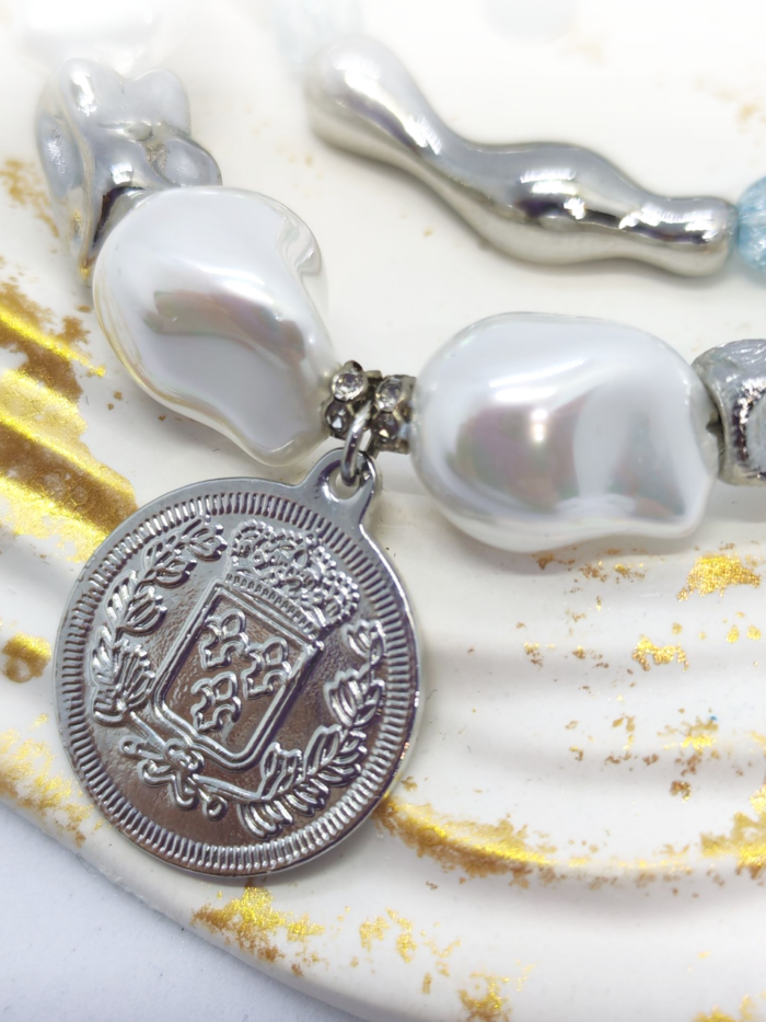 Браслет с жемчугом Майорка и сахарным кварцем: воплощение элегантности и индивидуальности Ищете украшение, которое подчеркнёт вашу утончённость и добавит нотку роскоши в любой образ? Представляем вам эксклюзивный браслет, сочетающий в себе изысканность жемчуга, нежность кварца и изящество серебряных элементов. Почему этот браслет заслуживает вашего внимания? · Роскошный дизайн. Крупные жемчужные бусины неправильной формы создают ощущение природной гармонии и уникальности. Нежно-голубой кварц напоминает о морском бризе и добавляет свежести образу. · Сочетание материалов. Серебряные элементы разной формы (гладкие, фактурные, изогнутые) создают интересную игру линий и текстур, делая браслет по-настоящему уникальным. · Особая деталь — монета-подвеска. Центральный элемент украшения — стилизованная монета с рельефным изображением. Она придаёт браслету винтажный шарм и делает его настоящим акцентом в образе. · Универсальность. Этот браслет легко сочетается как с повседневной одеждой, так и с вечерними нарядами. Он подойдёт для офиса, романтического ужина или торжественного мероприятия. · Три в одном. Этот аксессуар можно разделить на три самостоятельных браслета. Можно носить все сразу или по оному... Все, как пожелает ваше настроение · Качество исполнения. Каждый элемент тщательно подобран и надёжно закреплён. Браслет удобен в носке и не теряет внешний вид со временем. Идеальный подарок! Ищете подарок для особенной женщины? Этот браслет станет символом вашей заботы и внимания. Он подойдёт как для молодой девушки, так и для зрелой дамы, ценящей классику и элегантность. Не упустите возможность пополнить свою коллекцию украшений настоящим произведением искусства! Добавьте этот браслет в корзину уже сегодня и позвольте себе наслаждаться его красотой каждый день. Для заказа и по всем вопросам обращайтесь Телефон: +79817339605 WhatsApp: wa.me/79817339605 Группа в Telegram: t.me/LanaMir03 Сообщения группы VK: vk.me/lanamirc Группа VK, где вы найдете еще больше украшений: https://vk.com/lanamirc Или можно оформить заказ и задать вопрос прямо здесь, на нашем маркетплейсе https://marketcraft.ru/store/lanamir/ Нас находят по запросам: Браслет ручной работы, жемчуг, кварц, сахарный кварц, серебро, бусины, подвеска-монета, винтажный стиль, элегантность, украшение, женский аксессуар, ручная работа, изысканность, перламутр, голубые бусины, декоративные элементы, стильный браслет, ювелирное изделие, аксессуар для образа, дизайнерский браслет, браслет с камнями, тройной браслет