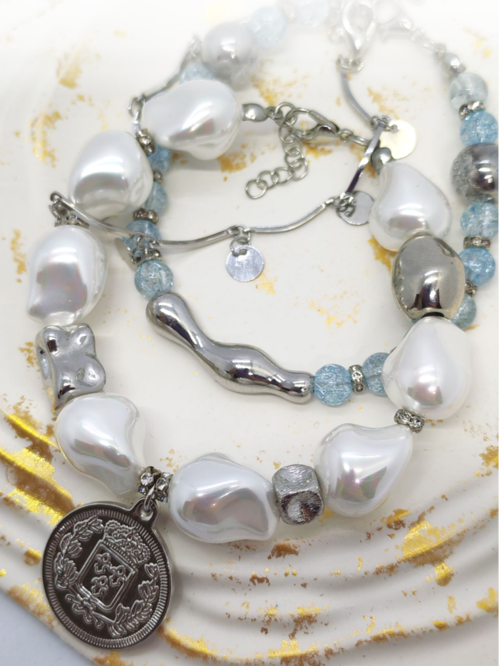 Браслет с жемчугом Майорка и сахарным кварцем: воплощение элегантности и индивидуальности Ищете украшение, которое подчеркнёт вашу утончённость и добавит нотку роскоши в любой образ? Представляем вам эксклюзивный браслет, сочетающий в себе изысканность жемчуга, нежность кварца и изящество серебряных элементов. Почему этот браслет заслуживает вашего внимания? · Роскошный дизайн. Крупные жемчужные бусины неправильной формы создают ощущение природной гармонии и уникальности. Нежно-голубой кварц напоминает о морском бризе и добавляет свежести образу. · Сочетание материалов. Серебряные элементы разной формы (гладкие, фактурные, изогнутые) создают интересную игру линий и текстур, делая браслет по-настоящему уникальным. · Особая деталь — монета-подвеска. Центральный элемент украшения — стилизованная монета с рельефным изображением. Она придаёт браслету винтажный шарм и делает его настоящим акцентом в образе. · Универсальность. Этот браслет легко сочетается как с повседневной одеждой, так и с вечерними нарядами. Он подойдёт для офиса, романтического ужина или торжественного мероприятия. · Три в одном. Этот аксессуар можно разделить на три самостоятельных браслета. Можно носить все сразу или по оному... Все, как пожелает ваше настроение · Качество исполнения. Каждый элемент тщательно подобран и надёжно закреплён. Браслет удобен в носке и не теряет внешний вид со временем. Идеальный подарок! Ищете подарок для особенной женщины? Этот браслет станет символом вашей заботы и внимания. Он подойдёт как для молодой девушки, так и для зрелой дамы, ценящей классику и элегантность. Не упустите возможность пополнить свою коллекцию украшений настоящим произведением искусства! Добавьте этот браслет в корзину уже сегодня и позвольте себе наслаждаться его красотой каждый день. Для заказа и по всем вопросам обращайтесь Телефон: +79817339605 WhatsApp: wa.me/79817339605 Группа в Telegram: t.me/LanaMir03 Сообщения группы VK: vk.me/lanamirc Группа VK, где вы найдете еще больше украшений: https://vk.com/lanamirc Или можно оформить заказ и задать вопрос прямо здесь, на нашем маркетплейсе https://marketcraft.ru/store/lanamir/ Нас находят по запросам: Браслет ручной работы, жемчуг, кварц, сахарный кварц, серебро, бусины, подвеска-монета, винтажный стиль, элегантность, украшение, женский аксессуар, ручная работа, изысканность, перламутр, голубые бусины, декоративные элементы, стильный браслет, ювелирное изделие, аксессуар для образа, дизайнерский браслет, браслет с камнями, тройной браслет
