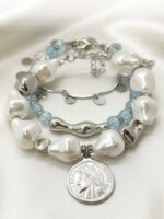 Браслет с жемчугом Майорка и сахарным кварцем: воплощение элегантности и индивидуальности Ищете украшение, которое подчеркнёт вашу утончённость и добавит нотку роскоши в любой образ? Представляем вам эксклюзивный браслет, сочетающий в себе изысканность жемчуга, нежность кварца и изящество серебряных элементов. Почему этот браслет заслуживает вашего внимания? · Роскошный дизайн. Крупные жемчужные бусины неправильной формы создают ощущение природной гармонии и уникальности. Нежно-голубой кварц напоминает о морском бризе и добавляет свежести образу. · Сочетание материалов. Серебряные элементы разной формы (гладкие, фактурные, изогнутые) создают интересную игру линий и текстур, делая браслет по-настоящему уникальным. · Особая деталь — монета-подвеска. Центральный элемент украшения — стилизованная монета с рельефным изображением. Она придаёт браслету винтажный шарм и делает его настоящим акцентом в образе. · Универсальность. Этот браслет легко сочетается как с повседневной одеждой, так и с вечерними нарядами. Он подойдёт для офиса, романтического ужина или торжественного мероприятия. · Три в одном. Этот аксессуар можно разделить на три самостоятельных браслета. Можно носить все сразу или по оному... Все, как пожелает ваше настроение · Качество исполнения. Каждый элемент тщательно подобран и надёжно закреплён. Браслет удобен в носке и не теряет внешний вид со временем. Идеальный подарок! Ищете подарок для особенной женщины? Этот браслет станет символом вашей заботы и внимания. Он подойдёт как для молодой девушки, так и для зрелой дамы, ценящей классику и элегантность. Не упустите возможность пополнить свою коллекцию украшений настоящим произведением искусства! Добавьте этот браслет в корзину уже сегодня и позвольте себе наслаждаться его красотой каждый день. Для заказа и по всем вопросам обращайтесь Телефон: +79817339605 WhatsApp: wa.me/79817339605 Группа в Telegram: t.me/LanaMir03 Сообщения группы VK: vk.me/lanamirc Группа VK, где вы найдете еще больше украшений: https://vk.com/lanamirc Или можно оформить заказ и задать вопрос прямо здесь, на нашем маркетплейсе https://marketcraft.ru/store/lanamir/ Нас находят по запросам: Браслет ручной работы, жемчуг, кварц, сахарный кварц, серебро, бусины, подвеска-монета, винтажный стиль, элегантность, украшение, женский аксессуар, ручная работа, изысканность, перламутр, голубые бусины, декоративные элементы, стильный браслет, ювелирное изделие, аксессуар для образа, дизайнерский браслет, браслет с камнями, тройной браслет